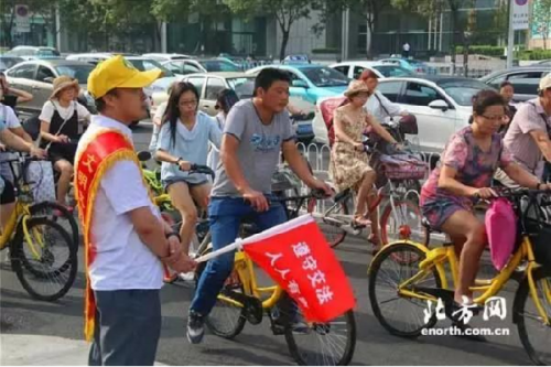 志愿者守在重要路口维护非机动车的秩序，并向市民宣传文明出行理念