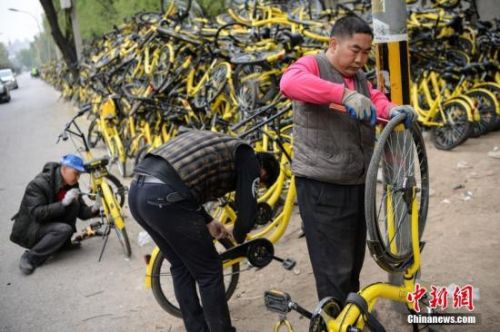 资料图：工作人员正在修理仍可修复的单车。 <a target='_blank' href='http://www.chinanews.com/'>中新社</a>记者 崔楠 摄
