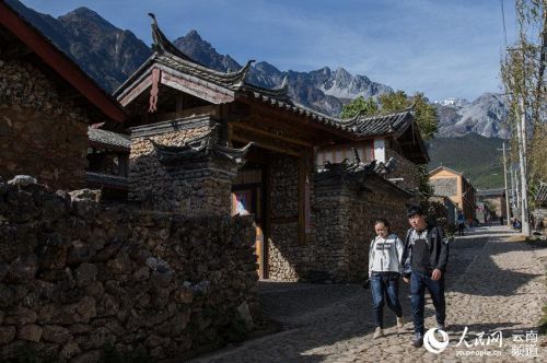 两名游客从玉湖村中走过 人民网 薛丹 摄