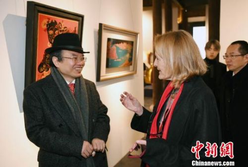 北京大学艺术学院副院长、福州国际漆艺双年展策展人彭锋(左一)与一名来自澳大利亚的艺术家观展交流。　记者刘可耕 摄